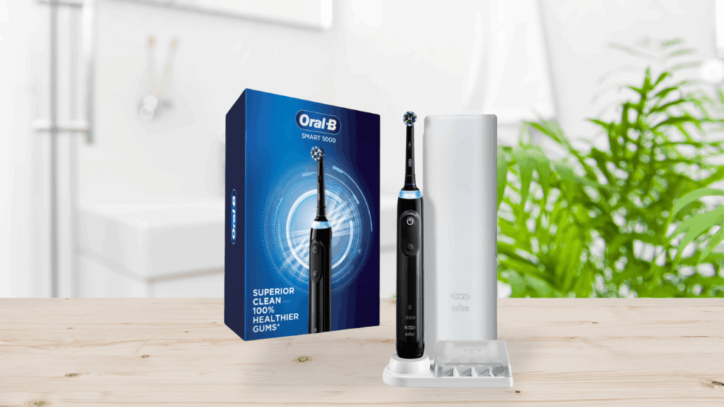 Oral-B Smart 5000 electric toothbrush with packaging and travel case on a wooden bathroom counter.